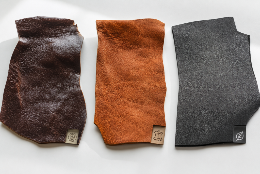 Three leather samples showing the difference between traditional chrome-tanned leather and sustainable leather production impact alternatives, illustrating choices for ethical sourcing.